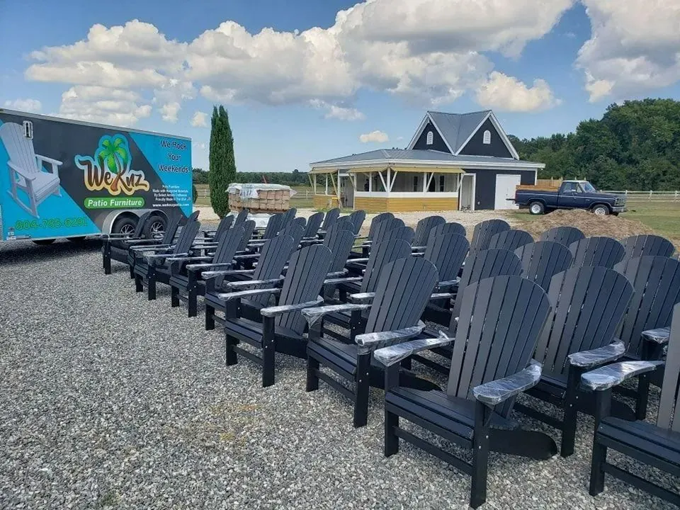 Long rows of dark gray poly Adirondack chairs outside the Weknz trailer