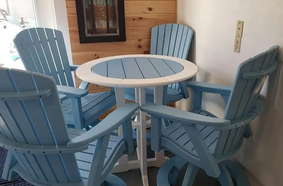Light blue poly swivel chairs around a round two-tone table in the showroom